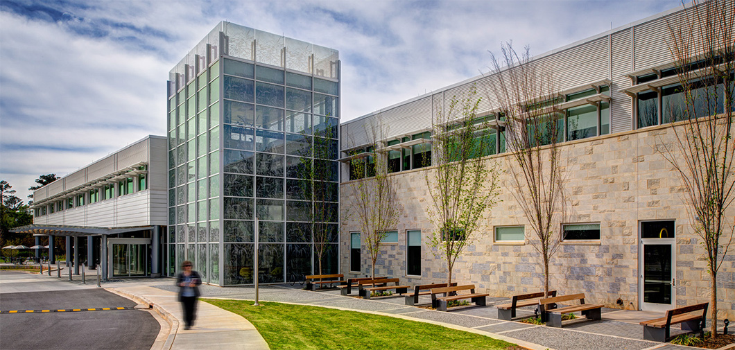 The sweeping, curved entrance to St. Francis Cancer Center creates a soothing, nature-inspired welcome for visitors, featuring a tree-lined seating area and calming colors.